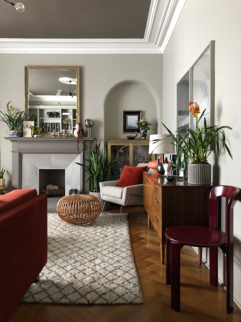 Living room with cream and brown walls, wooden parquet floor, mix of 70's furnishings and fireplace
