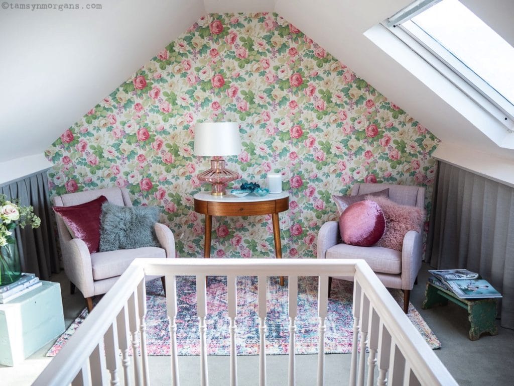 Attic room with floral wallpaper and two dusty pink chairs